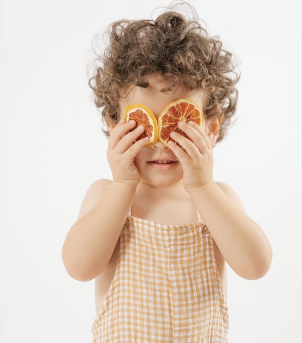 Foto de un niño jugando a taparse los ojos con cascaras de naranja